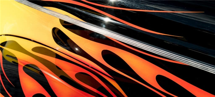 Оранжево-красный рисунок пламени на черном автомобиле.