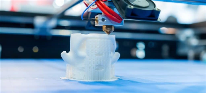 3D-принтер печатает белую структуру.