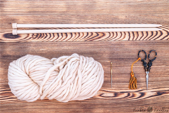 Материалы, которые понадобятся для вязания шарфа для начинающих: пряжа, спицы, гобеленовая игла и ножницы.