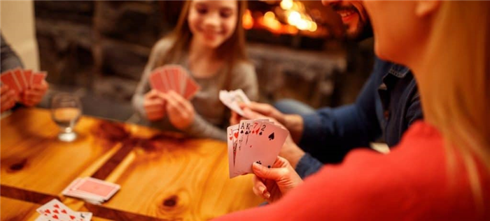 Семья играет в карты за столом
