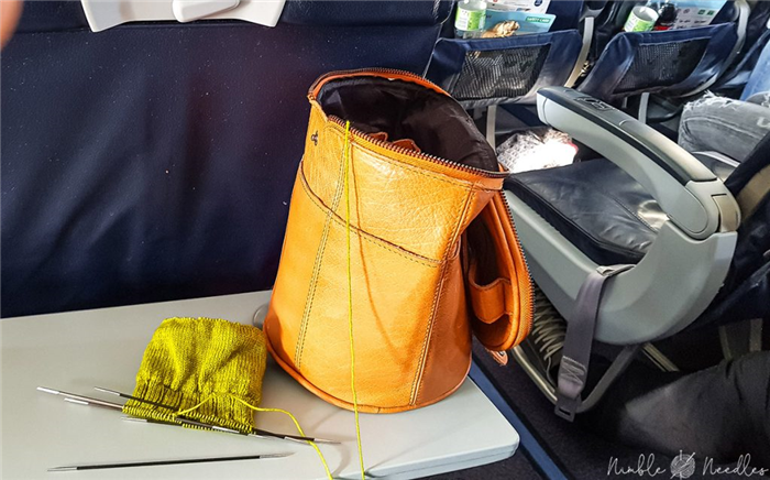 вязаный проект и красивая кожаная сумка с моими спицами в самолете в европе