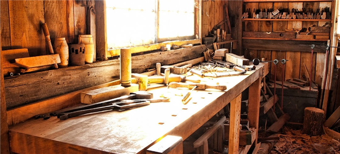 Деревенская, простая деревообрабатывающая мастерская с большим окном для света.