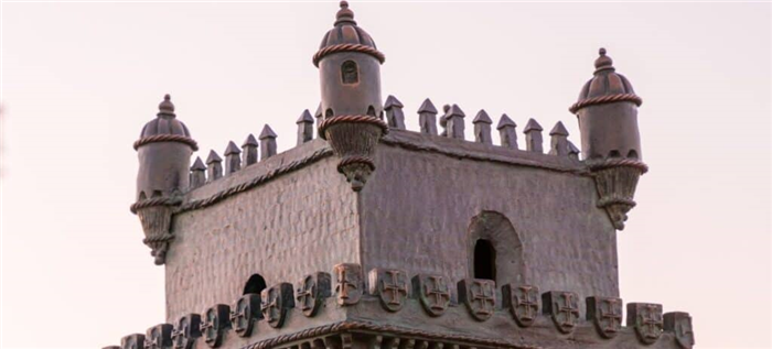 Верхняя часть миниатюрной башни замка, демонстрирующая сложные детали конструкции.