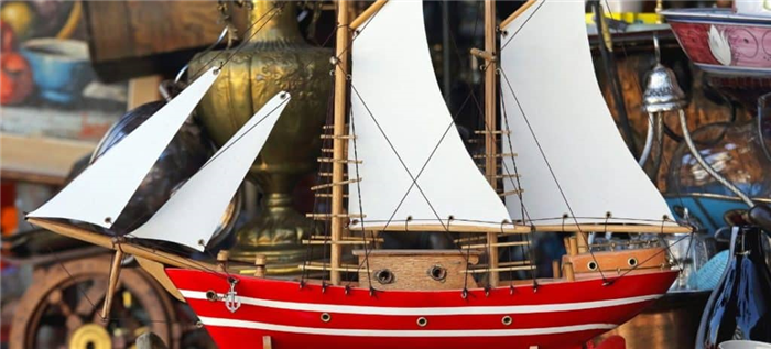 Завершенная деревянная модель корабля с корпусом в красную и белую полоску.