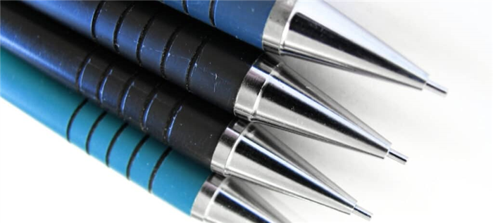 Четыре синих механических карандаша на белом фоне.