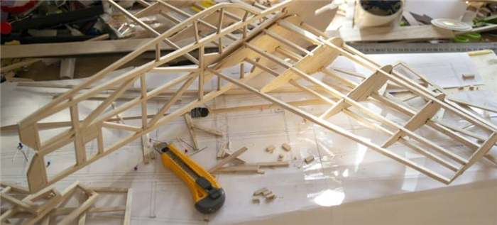 Почти готовая модель самолета из бальзового дерева и различные детали и инструменты.